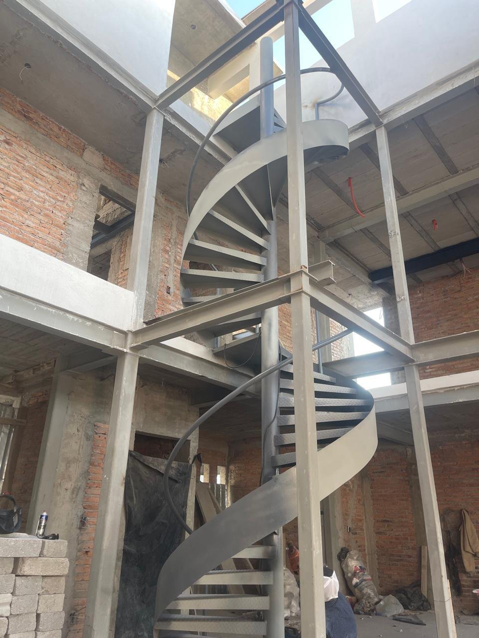 Escalera de caracol metálica montada entre dos niveles