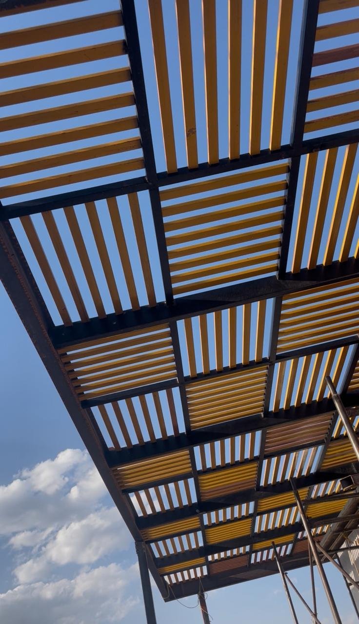 Pérgola de listones. Acero y madera a contraluz.